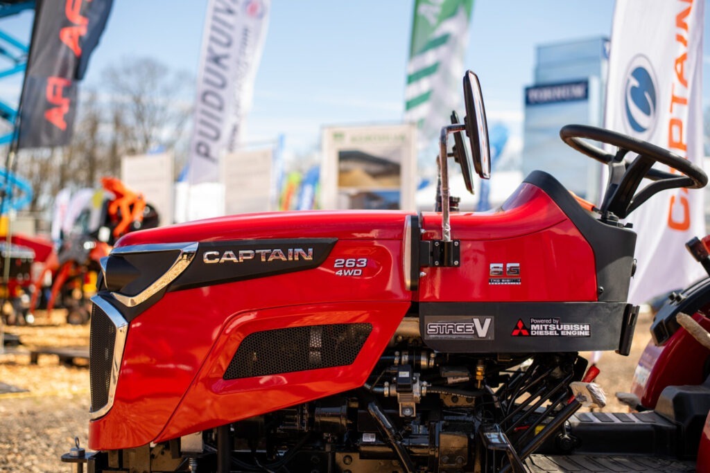 Maamessil 2026 väljas eksponeeritud Kone Agro kaubamärgiga punase Captain 263 4WD traktori külgvaade, millel on nähtavad logod ja taustal on hägused bännerid ja seadmed.